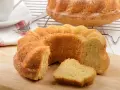 Ein goldbrauner Paradiescreme Kuchen, frisch gebacken und mit einem Stück abgetrennt, wartet auf Genuss.