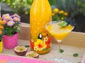 Ein tropischer Solero Cocktail mit Passionsfrucht, Blumen und einem lustigen Schnurrbart-Garnitur.