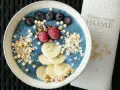 Blauer Smoothie-Bowl mit Blaubeeren, Himbeeren, Bananenscheiben und Granola. Perfekt für gesunde smoothie rezepte.
