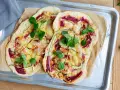 Zwei Flammkuchen mit Zucchini und Roter Bete, garniert mit frischen Blättern. Eine histaminarme Alternative, bei der man auf Weintrauben verzichtet.
