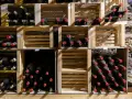 Holzregale mit vielen Flaschen Wein, die perfekt zum Wein lagern bereitstehen.