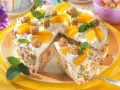 Eine köstliche Giotto Torte mit Pfirsichspalten, Sahne und gehackten Mandeln. Kleine Pralinen und Minzblätter zieren die Torte.