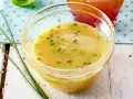 Gelbe Vinaigrette mit Schnittlauch in einer Glasschale, perfekt für frische Salat-Dressing-Ideen.