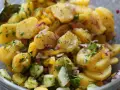 Omas sonntagsessen: Kartoffelsalat mit Gurken, Zwiebeln und frischen Kräutern, perfekt gewürzt.