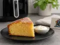 Ein saftiges Stück Kuchen im Airfryer, serviert mit Sahne. Perfekt für süße Momente!