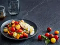 Bunter Tomatensalat mit cremiger Burrata, garniert mit frischen Kräutern. Ein köstlicher Genuss!