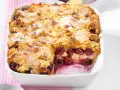 Omas Kirschenmichel Rezept: Ein goldbrauner Auflauf mit saftigen Kirschen und knuspriger Streuselhaube, bestäubt mit Puderzucker.