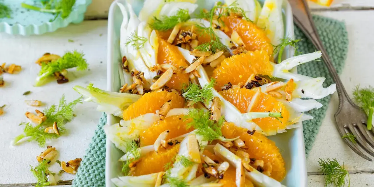 Erfrischender Fenchelsalat mit saftigen Orangen, garniert mit gerösteten Mandeln und Dill. Ein leichter Genuss.
