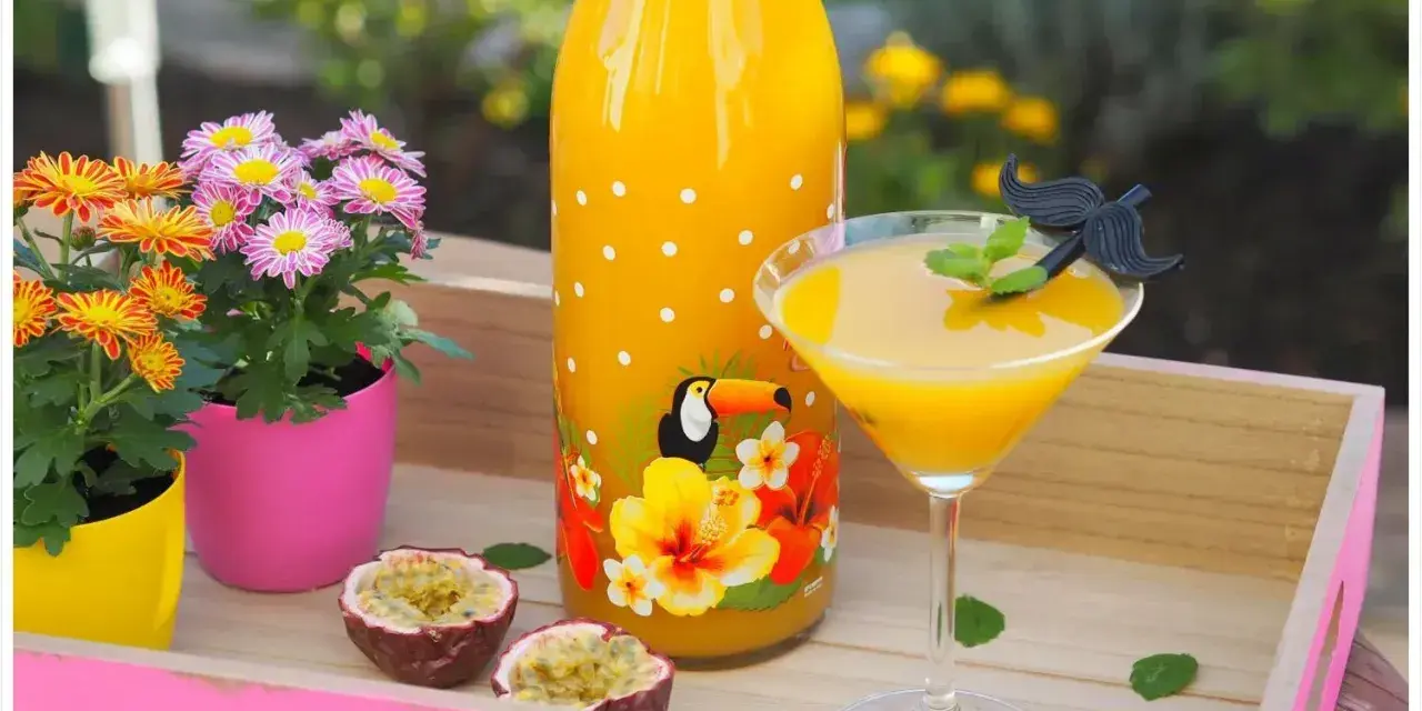 Ein tropischer Solero Cocktail mit Passionsfrucht, Blumen und einem lustigen Schnurrbart-Garnitur.
