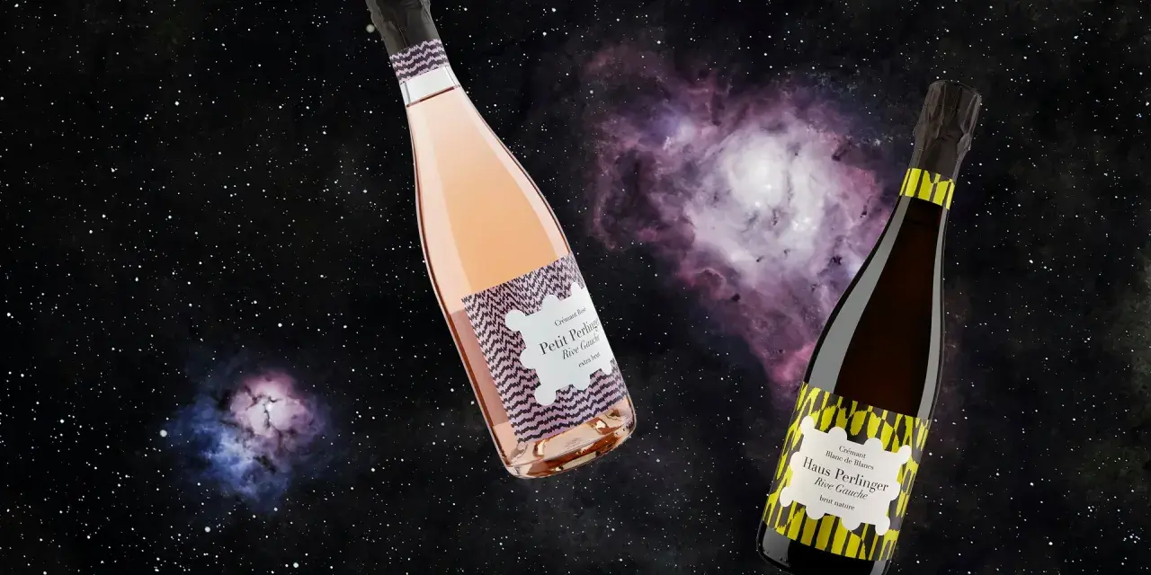 Zwei Flaschen Crémant, eine Rosé, eine Blanc de Blancs, schweben im Sternenhimmel. Was ist Crémant? Ein prickelnder Genuss!