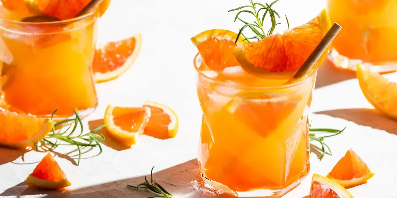 Erfrischender, fruchtiger Gin Cocktail mit Orangenscheiben und Rosmarin. Perfekt für einen sonnigen Tag.