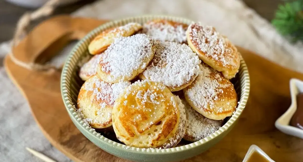 Köstliche Poffertjes, bestäubt mit Puderzucker, warten auf das Poffertjes Rezept. Ein süßer Genuss!