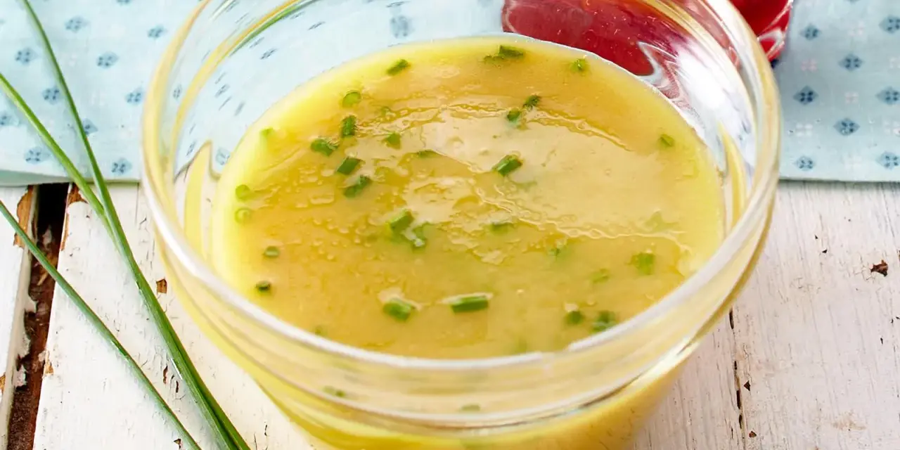 Gelbe Vinaigrette mit Schnittlauch in einer Glasschale, perfekt für frische Salat-Dressing-Ideen.
