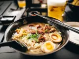 Eine dampfende Schüssel Ramen mit Nudeln, Fleisch, Ei und Frühlingszwiebeln. Das ist, was Ramen ist: ein herzhaftes japanisches Gericht.