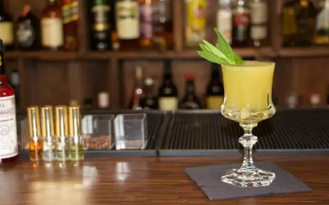 Ein erfrischender gelber Longdrink mit Minze, bereit für den Genuss. Perfekt für die besten Longdrinks.