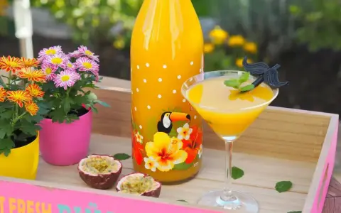 Ein tropischer Solero Cocktail mit Passionsfrucht, Blumen und einem lustigen Schnurrbart-Garnitur.