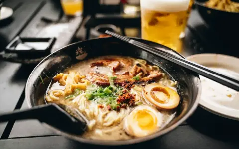 Eine dampfende Schüssel Ramen mit Nudeln, Fleisch, Ei und Frühlingszwiebeln. Das ist, was Ramen ist: ein herzhaftes japanisches Gericht.