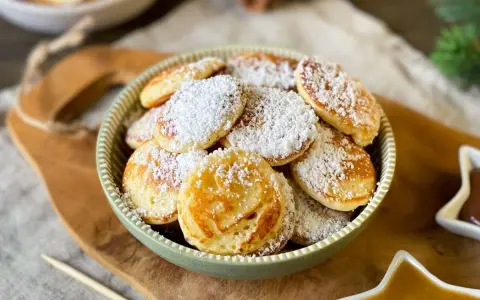 Köstliche Poffertjes, bestäubt mit Puderzucker, warten auf das Poffertjes Rezept. Ein süßer Genuss!
