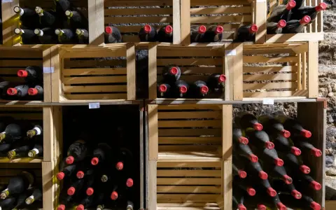 Holzregale mit vielen Flaschen Wein, die perfekt zum Wein lagern bereitstehen.