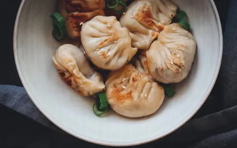 Gedämpfte und gebratene Dumplings mit Sesam und Frühlingszwiebeln, ein köstliches Dumplings Rezept.