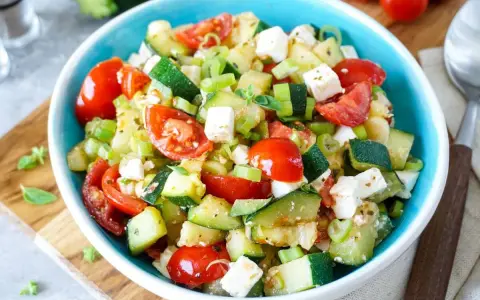 Erfrischender Zucchini Salat mit Tomaten und Feta. Ein leichtes Rezept für heiße Tage.
