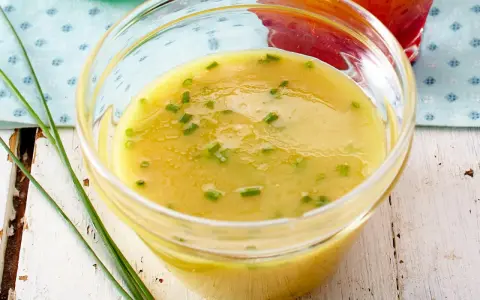 Gelbe Vinaigrette mit Schnittlauch in einer Glasschale, perfekt für frische Salat-Dressing-Ideen.