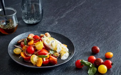 Bunter Tomatensalat mit cremiger Burrata, garniert mit frischen Kräutern. Ein köstlicher Genuss!