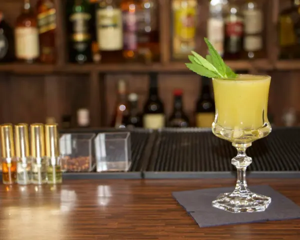 Ein erfrischender gelber Longdrink mit Minze, bereit für den Genuss. Perfekt für die besten Longdrinks.