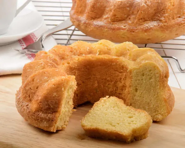 Ein goldbrauner Paradiescreme Kuchen, frisch gebacken und mit einem Stück abgetrennt, wartet auf Genuss.
