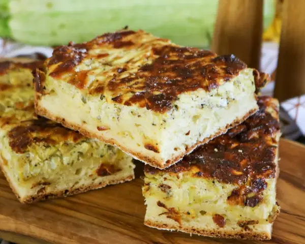 Herzhafte Zucchinikuchen-Stücke auf Holzbrett. Ein köstliches Rezept mit Zucchini, das perfekt für jede Mahlzeit ist.