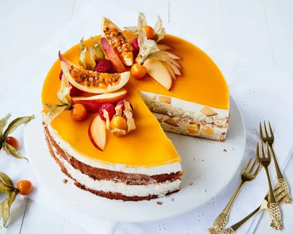 Eine köstliche Pfirsich Maracuja Torte mit frischen Früchten und einer leuchtend orangen Glasur.