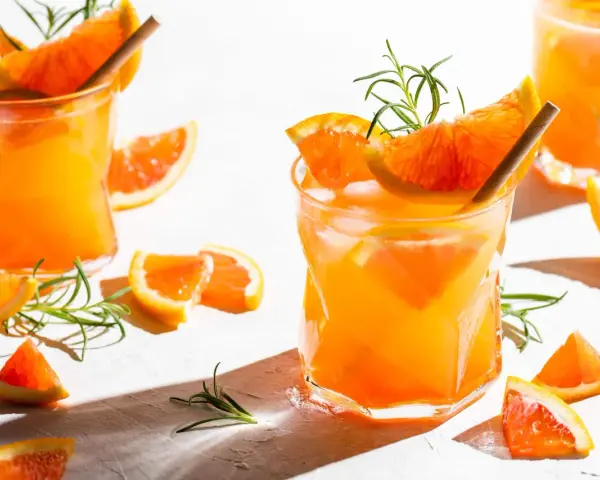 Erfrischender, fruchtiger Gin Cocktail mit Orangenscheiben und Rosmarin. Perfekt für einen sonnigen Tag.