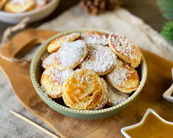 Köstliche Poffertjes, bestäubt mit Puderzucker, warten auf das Poffertjes Rezept. Ein süßer Genuss!