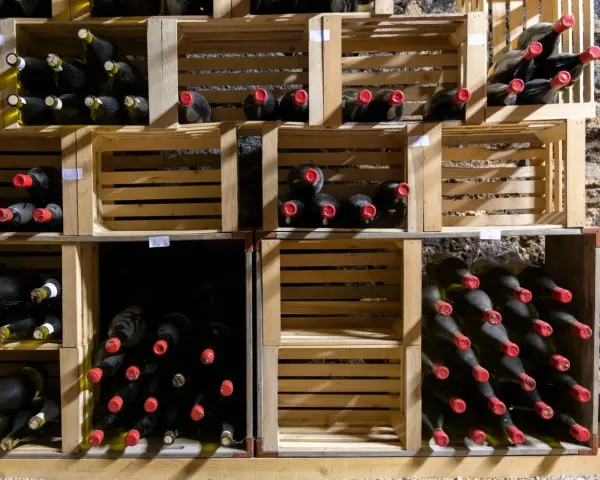 Holzregale mit vielen Flaschen Wein, die perfekt zum Wein lagern bereitstehen.