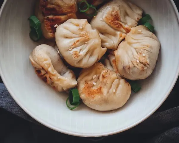 Gedämpfte und gebratene Dumplings mit Sesam und Frühlingszwiebeln, ein köstliches Dumplings Rezept.