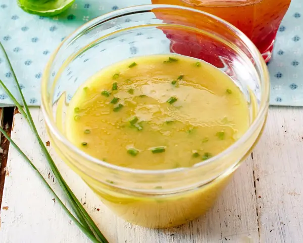 Gelbe Vinaigrette mit Schnittlauch in einer Glasschale, perfekt für frische Salat-Dressing-Ideen.