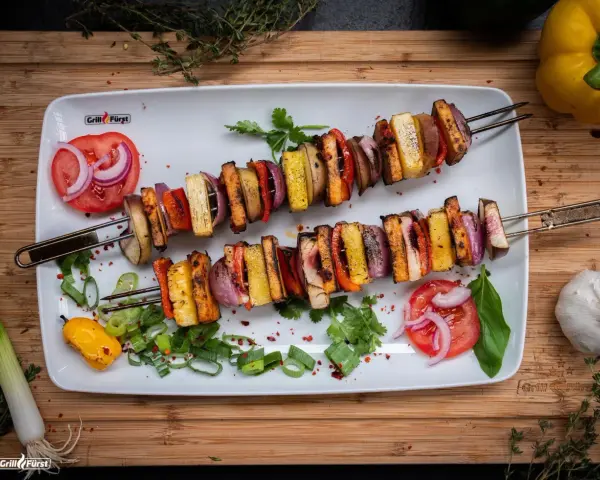 Zwei Spieße mit gegrilltem Gemüse und Tofu, perfekt für ausgefallene Grillrezepte. Bunt und lecker!