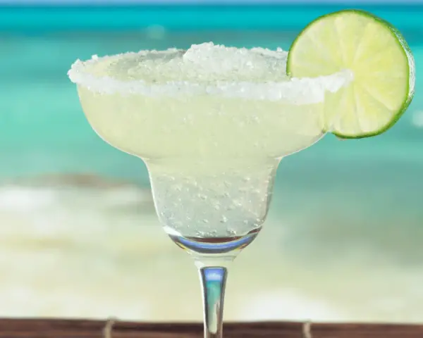 Erfrischende Margarita mit Salzrand und Limettenscheibe, perfekt für ein Strand-Margarita-Rezept.