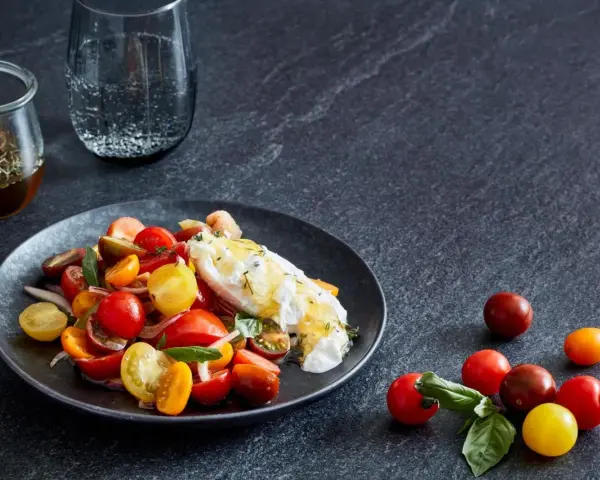 Bunter Tomatensalat mit cremiger Burrata, garniert mit frischen Kräutern. Ein köstlicher Genuss!