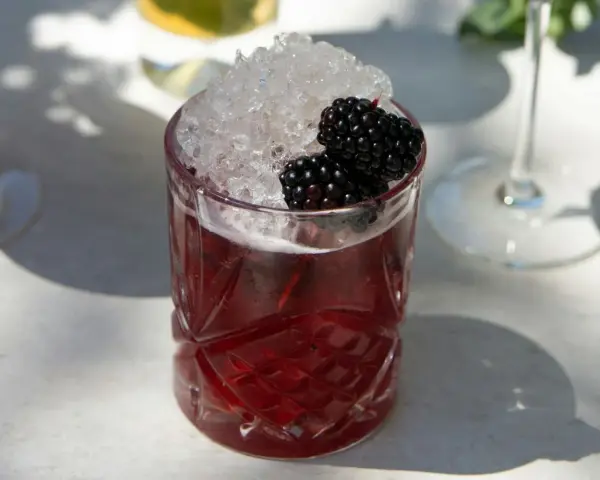 Erfrischender Brombeer-Cocktail mit zerstoßenem Eis und frischen Beeren. Perfekt für sommerliche longdrink rezepte.