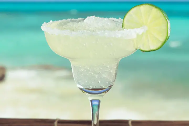 Erfrischende Margarita mit Salzrand und Limettenscheibe, perfekt für ein Strand-Margarita-Rezept.