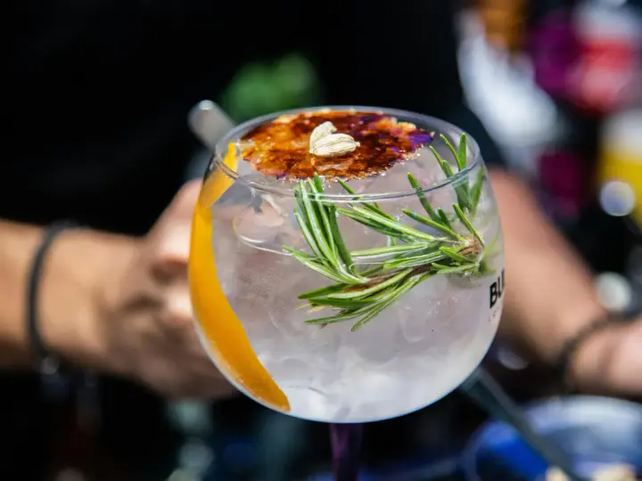 Ein erfrischender Gin Tonic mit Rosmarin und karamellisierter Orangenscheibe. Perfekt für einfache Gin Rezepte.
