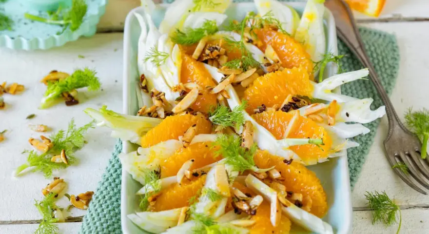 Erfrischender Fenchelsalat mit saftigen Orangen, garniert mit gerösteten Mandeln und Dill. Ein leichter Genuss.