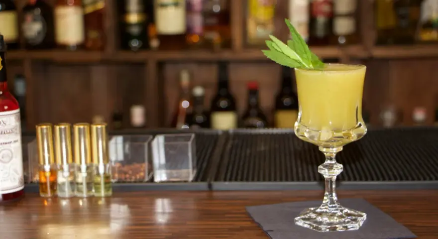 Ein erfrischender gelber Longdrink mit Minze, bereit für den Genuss. Perfekt für die besten Longdrinks.