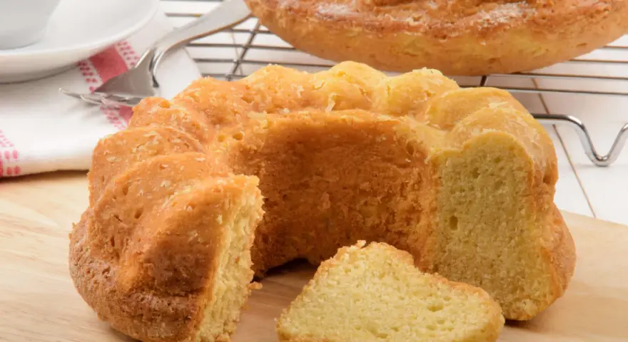 Ein goldbrauner Paradiescreme Kuchen, frisch gebacken und mit einem Stück abgetrennt, wartet auf Genuss.