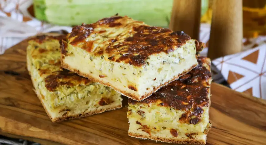 Herzhafte Zucchinikuchen-Stücke auf Holzbrett. Ein köstliches Rezept mit Zucchini, das perfekt für jede Mahlzeit ist.