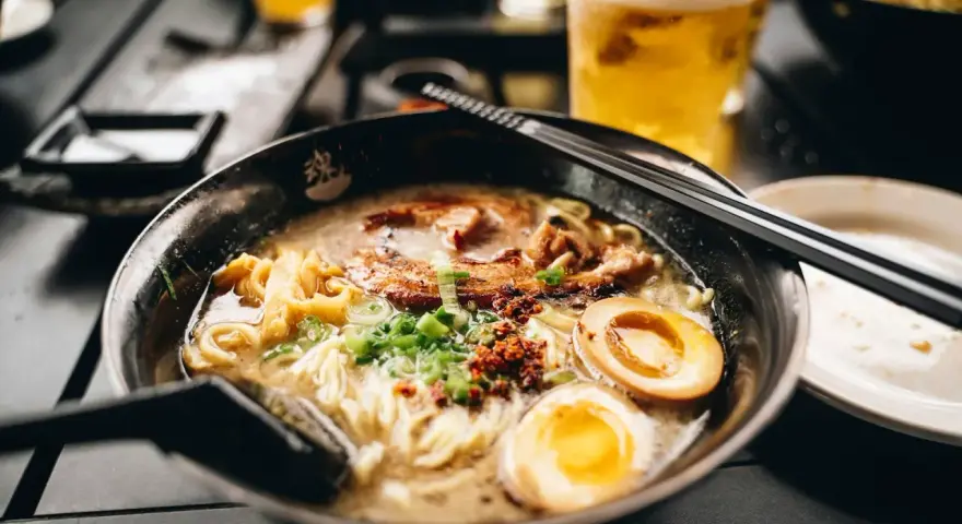 Eine dampfende Schüssel Ramen mit Nudeln, Fleisch, Ei und Frühlingszwiebeln. Das ist, was Ramen ist: ein herzhaftes japanisches Gericht.