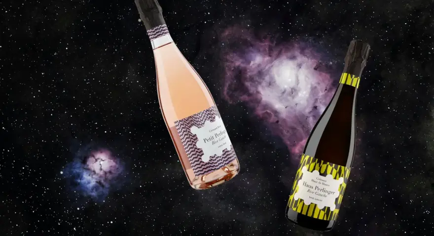 Zwei Flaschen Crémant, eine Rosé, eine Blanc de Blancs, schweben im Sternenhimmel. Was ist Crémant? Ein prickelnder Genuss!