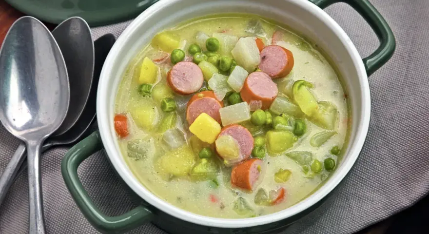 Herzhafter Kohlrabi-Eintopf mit Würstchen, Kartoffeln und Erbsen in cremiger Brühe. Ein deftiges Gericht für kalte Tage.