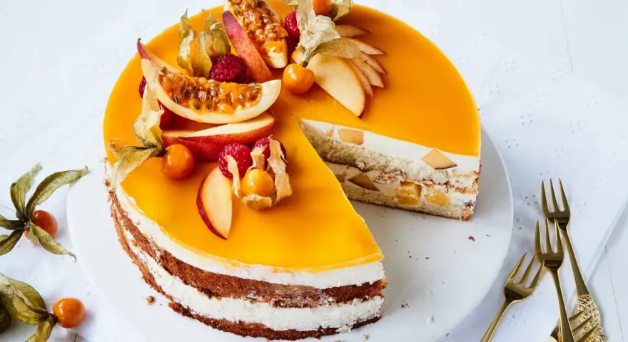 Eine köstliche Pfirsich Maracuja Torte mit frischen Früchten und einer leuchtend orangen Glasur.